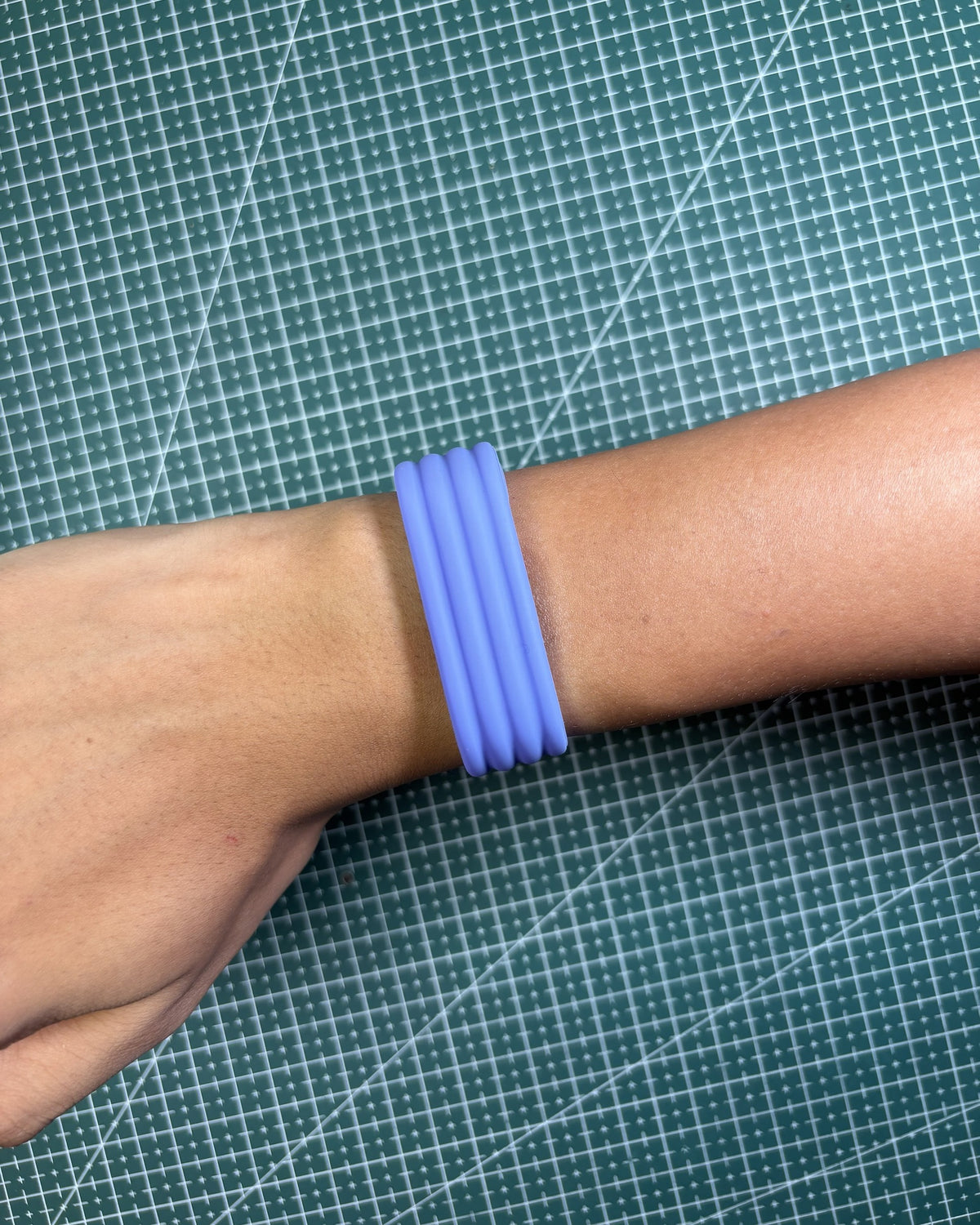 Fitbit Air Silicone Band in Lavender worn on wrist, top view