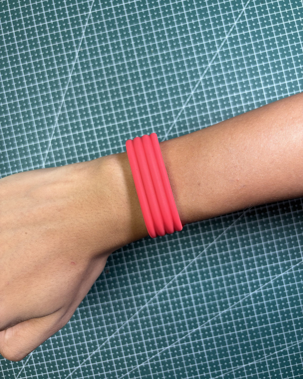 Fitbit Air Silicone Band in Red worn on wrist, top view